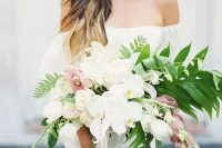 a chic cascading bouquet with white and light pink orchids and greenery for a romantic feel