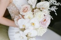 a chic cascading wedding bouquet of blush and light pink roses, white anthurium and orchids plus some white grasses