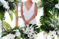 a chic tropical bouquet with white orchids and tropical leaves is a timeless idea