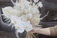 a classy white wedding bouquet of orchids, lunaria, anthurium, dried leaves and grasses is a lovely idea for an all-white wedding