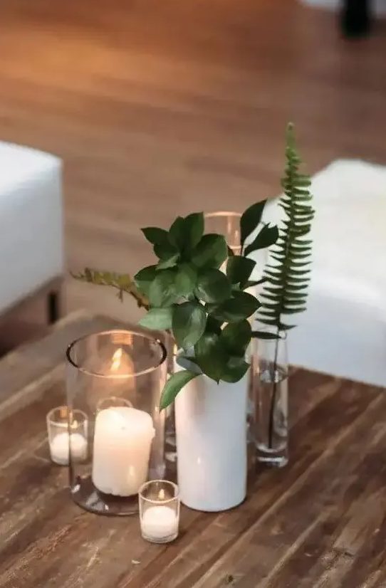 a cluster wedding centerpiece of pillar candles, greenery and fern is a great idea for a casual wedding