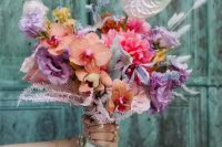 a colorful wedding bouquet of bold purple and pink blooms, peachy orchids and a neutral anthurium plus bunny tails is a lovely idea