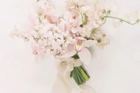 a delicate blush and white wedding bouquet with orchids and sweet peas, with neutral ribbons and beads for a spring bride