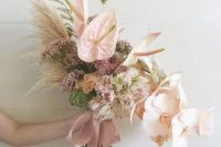a delicate wedding bouquet of blush orchids, anthurium, grasses, fillers and some seed pods is a cool idea for a neutral wedding