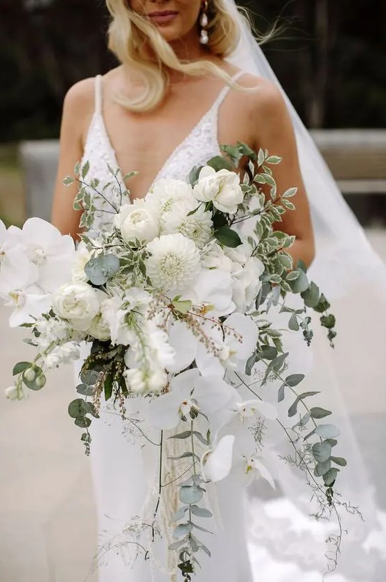a dimensional and textural white wedding bouquet of peony roses, orchids, dahlias and greenery is a fantastic idea