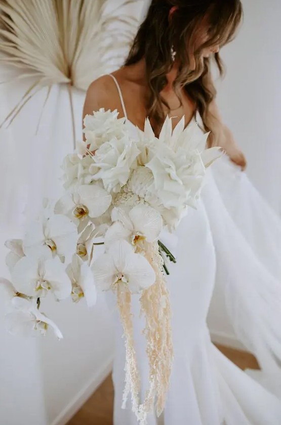 a fan white wedding bouquet of orchids, roses, dahlias, white fronds and some cascading touches is amazing