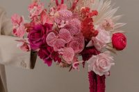 a fantastic pink wedding bouquet of hot pink and blush roses, pink orchids, billy balls and neutral fronds