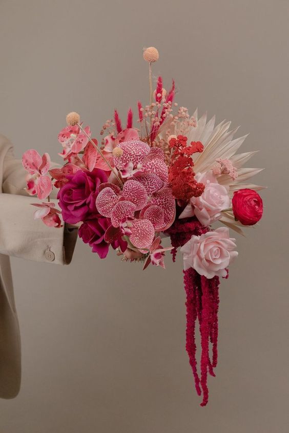a fantastic pink wedding bouquet of hot pink and blush roses, pink orchids, billy balls and neutral fronds