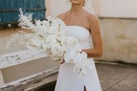 a lush white wedding bouquet with callas, orchids and some dried foliage, with a catchy shape and a cascading element is idea for a minimalist bride