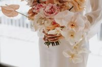 a neutral wedding bouquet of white and blush orchids, blush and white roses plus coffee-colored ones and some anthurium