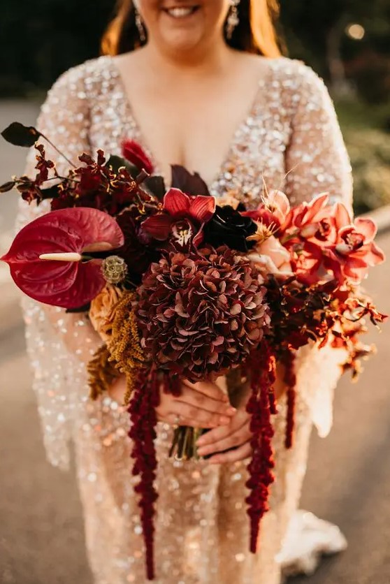 a refined burgundy wedding bouquet of hydrangeas, orchids, anthuriums, bold leaves and amaranthus for the fall