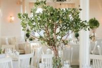 a simple yet stunning centerpiece with fresh greenery on branches is great idea for any season