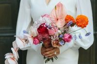 a stylish and catchy modern wedding bouquet of pink, red and blush blooms, orange and blue ones plus orchids is a cool idea for a modern bride