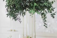 a tall eucalyptus centerpiece on a gilded frame is great for a modern wedding and  to save some table space