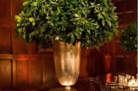 a tall leafy centerpiece in a large gold vase is all you need for modern rustic elegance at the table