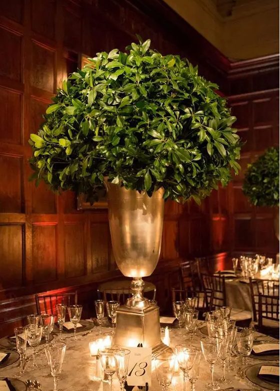 a tall leafy centerpiece in a large gold vase is all you need for modern rustic elegance at the table