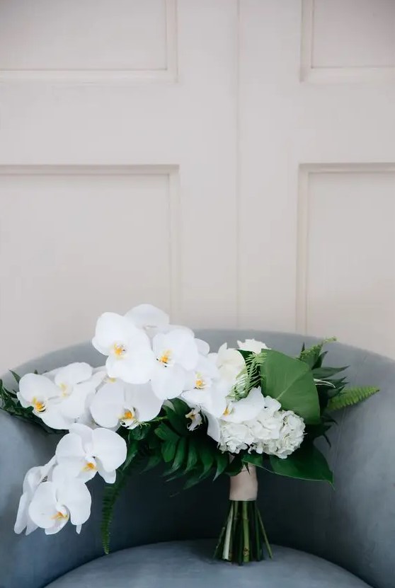 a textural and chic minimalist wedding bouquet of white orchids, hydrangeas and various foliage is a lovely idea to go for