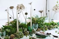 a woodland style wedding centerpiece of greenery, succulents, dired blooms and pinecones for a Nordic woodland summer or fall wedding