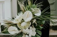 an elegant wedding bouquet of king proteas, anhturium, orchids, grasses, leaves is a fab idea for a trendy tropical bride