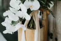 an elegant white wedding bouquet of cascading orchids, peonies, berries and foliage is a gorgeou sidea for a minimalist bride
