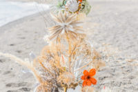 02 The wedding arch was hand crafted of corals, large blooms and apinted succulents plus driftwood for a creative look