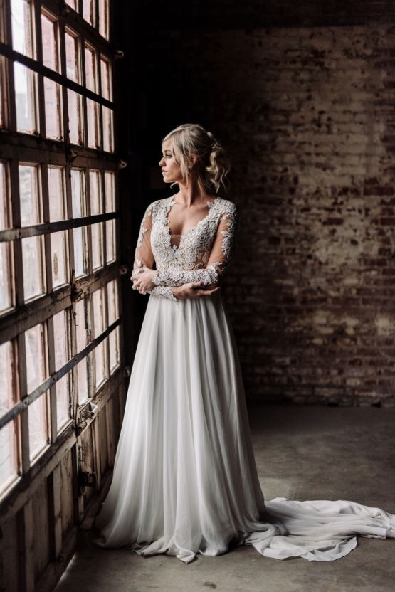 a wedding gown with a lace bodice with an illusion plunging neckline, long sleeves and a аlowy skirt with a train