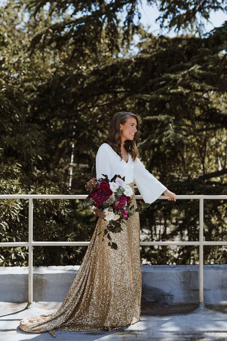 The second bride preferred a white top with bell sleeves and a gold glitter skirt with a train