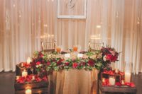 03 a sweetheart table decorated with crates with flower petals and candles on them for a romantic touch