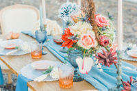 05 The wedding tablescape was done with coral and peachy tones, blue glasses and textiles and tall candles