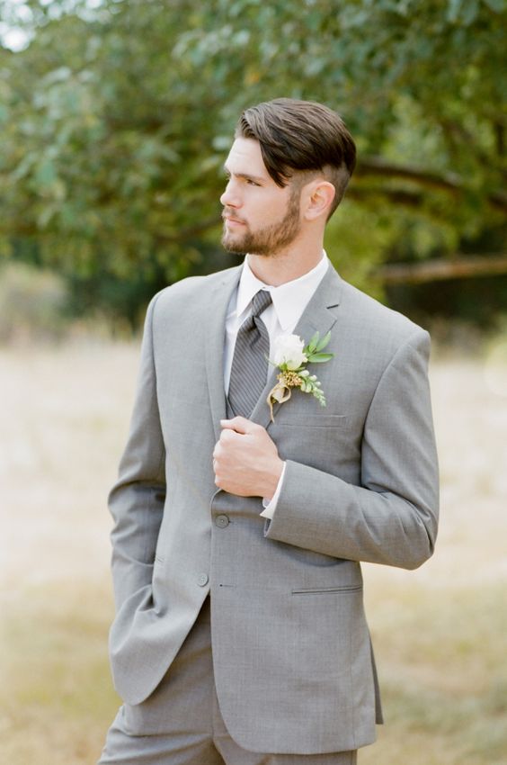 a grey two-piece wedding suit with a grey printed tie and a white shirt for a modern and fresh look