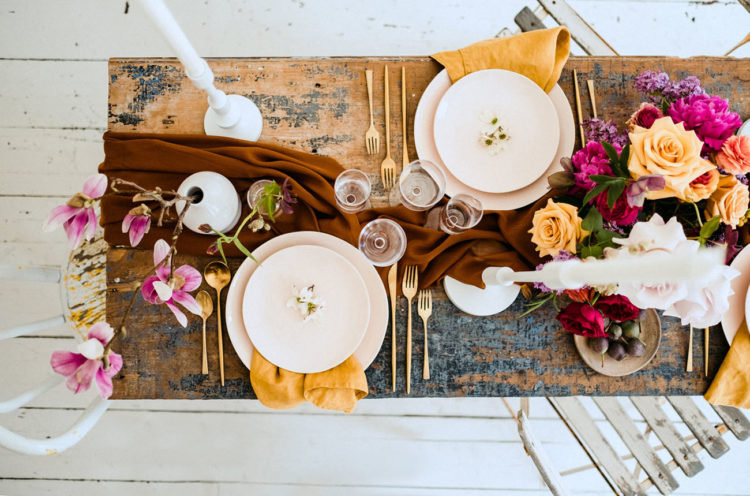 The shabby chic table was done with a rust table runner, mustard napkins, gold cutlery and bright and lush blooms