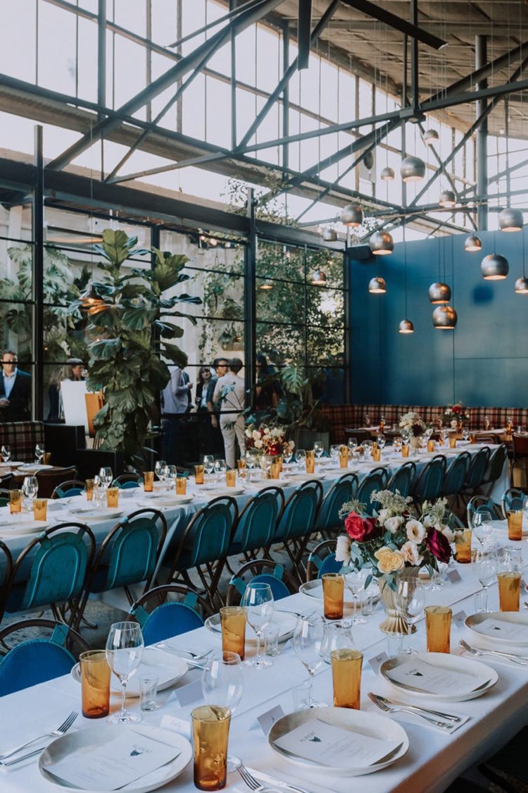 The wedding venue was industrial, with touches of blue and teal and amber glasses plus cute blooms