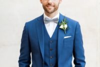 09 a bold blue three-piece suit, a white shirt and a grey bow tie for a classic elegant look