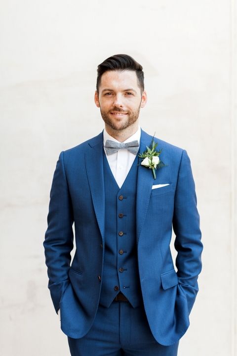 a bold blue three-piece suit, a white shirt and a grey bow tie for a classic elegant look