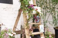 09 a rustic ladder with greenery and blooms in vases and botanical posters for a rustic wedding