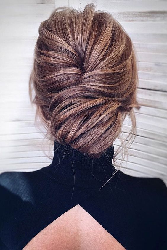 a super chic and elegant low chignon hairstyle with much volume and some bangs just wows