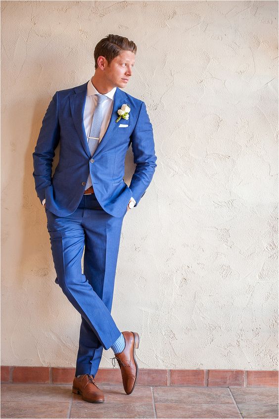 a bold blue suit, a white shirt, a light blue tie and brown leather shoes and a belt for a summer groom