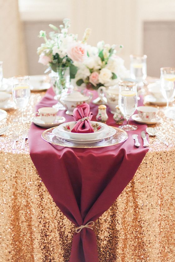 an adorable burgundy and gold tablescape with neutral blooms and floral plates