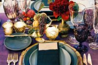 11 a decadent jewel tone tablescape with a deep purple table runner, purple goblets, gold flatware and a gold charger