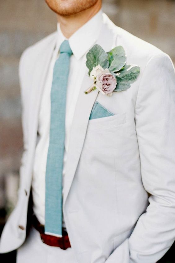 a white suit, a white shirt, a mint green tie and a mauve boutonniere for a summer garden wedding