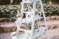 11 a whitewashed ladder with letters and flower arrangements in teacups for a vintage wedding