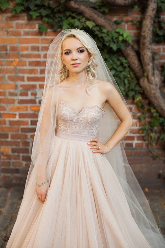 a strapless sweetheart neckline blush wedding dress with an embroidered bodice and a layered skirt
