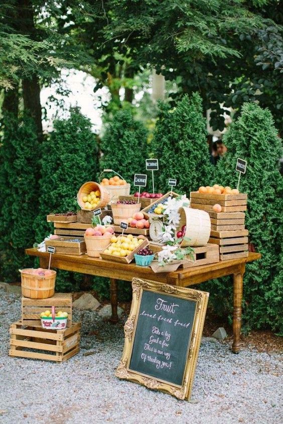 a wedding fruit table with crates with different fruits and cahlkboard tags for a rustic wedding