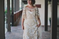 17 Dahlia gown of a nude shade with botanical white lace appliques, short sleeves and a catchy neckline