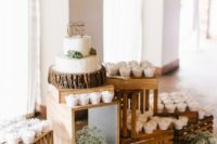 17 a dessert table with cupcakes and a wedding cake on display decorated with baby’s breath in jugs