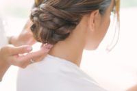17 a low twisted and braided bun with a sleek top looks very elegant and chic