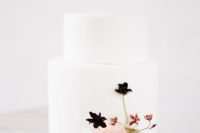 18 a minimalist wedding cake in white with some dark and blush blooms for a minimal wedding