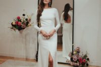 20 a minimalist sheath wedding dress with long sleeves, a high neckline, a front slit and a train