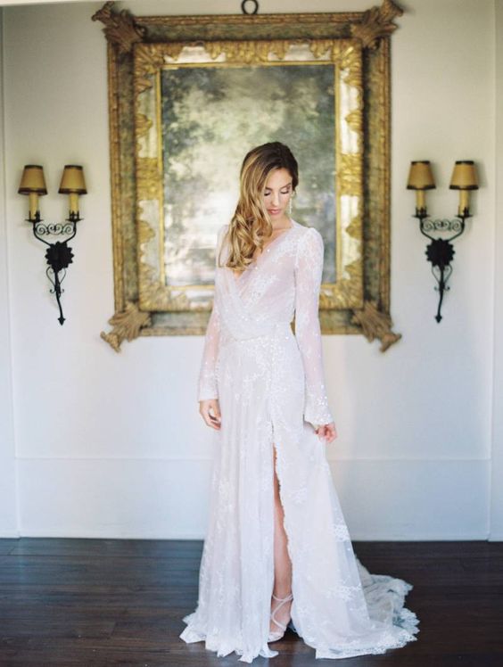 a modern wedding dress with a side slit, bell sleeves, a V-neckline and embellishments here and there