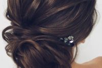 20 an elegant messy low updo with textures and a small rhinestone hairpiece to look effortlessly chic